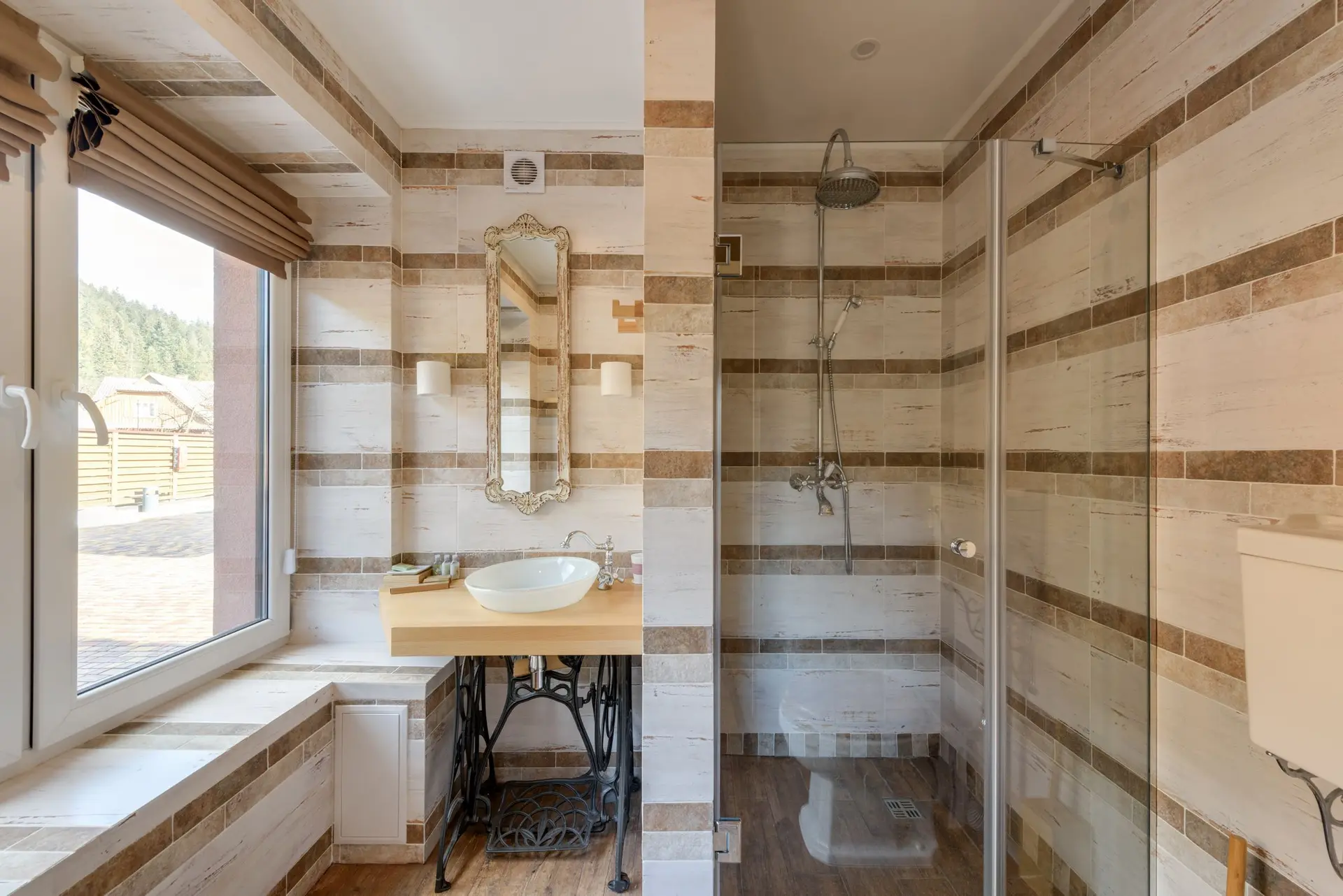 Baño con mueble de madera, lavabo de sobre encimera y ducha de obra con mampara de cristal